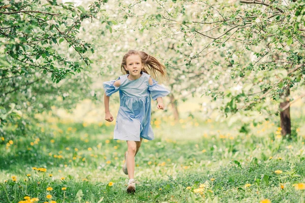 아름다운 봄날 꽃피는 사과 정원에 있는 사랑 스러운 어린 소녀 — 스톡 사진