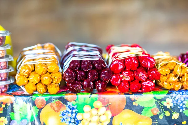 Multicolorido deliciosos doces georgianos frescos Churchkhela pendurados no mercado — Fotografia de Stock