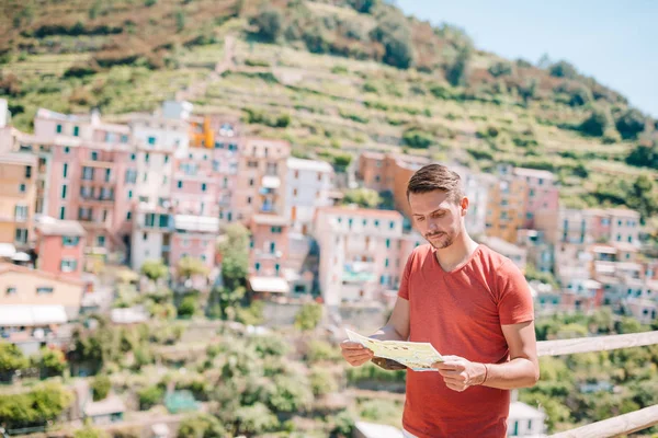 Młody człowiek turysta z mapą tło oszałamiające wsi, Manarola, Cinque Terre, Liguria, Włochy — Zdjęcie stockowe