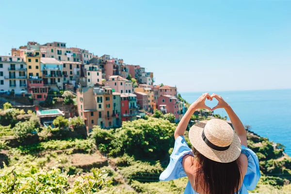 Szczęśliwa dziewczyna z rąk kształt serca na stary nadmorskiej miejscowości w Parku Narodowego Cinque Terre. Wakacje Europejskiej. — Zdjęcie stockowe