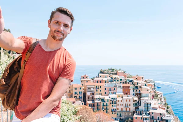 Joven turista en gafas de sol tomando selfie con vista panorámica de Manarola, Cinque Terre, Liguria, Italia —  Fotos de Stock