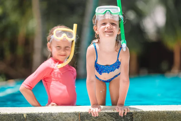 Adorable little girls playing in outdoor swimming pool — Stock Photo, Image
