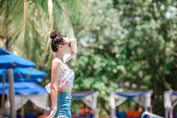 Hermosa chica joven relajándose cerca de la piscina — Foto de Stock