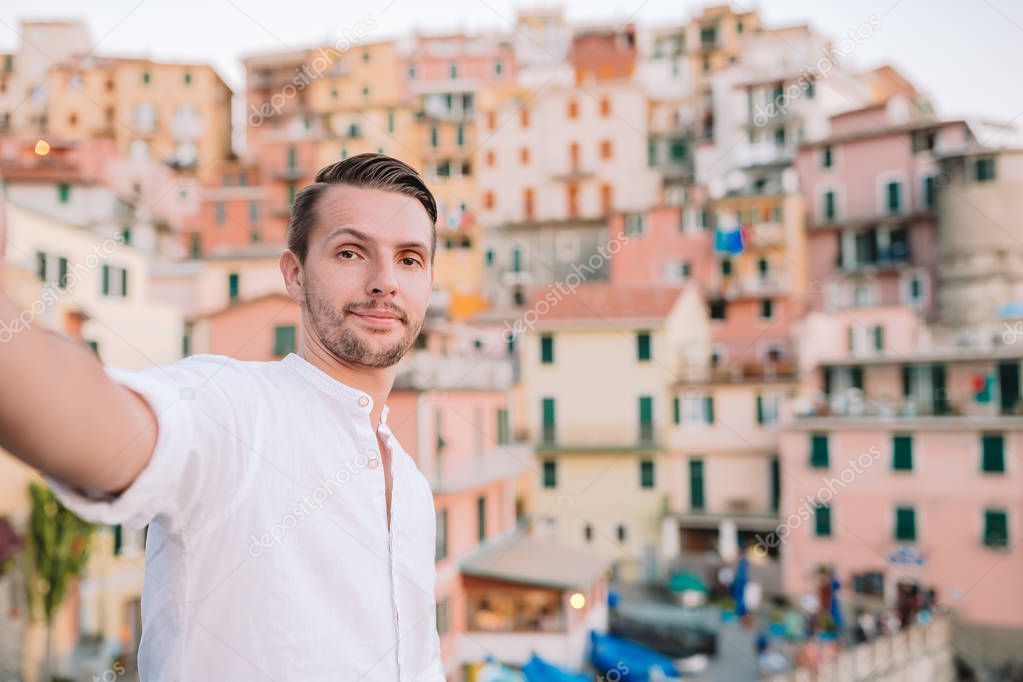 Young man taking selfie background beautiful Manarola village, Cinque Terre, Liguria
