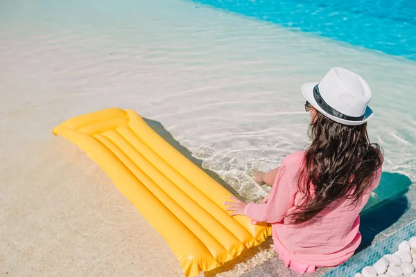 Schöne junge Frau entspannt sich im Schwimmbad. Glückliches Mädchen im Außenpool eines Luxushotels — Stockfoto