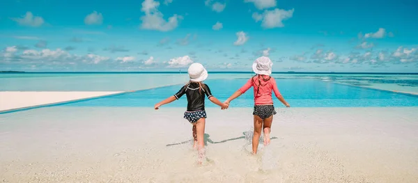 Adorable little girls playing in outdoor swimming pool — Stock Photo, Image