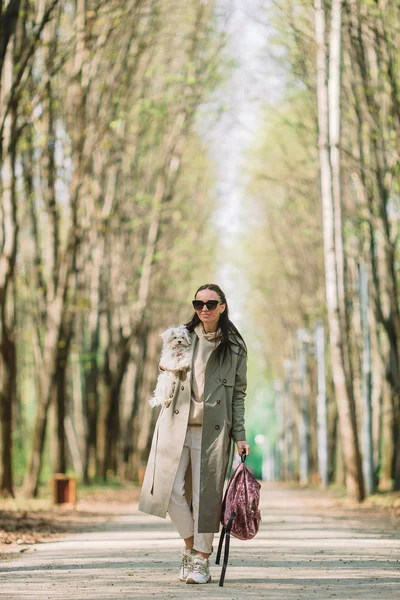 Jeune femme élégante promenades avec chien blanc — Photo