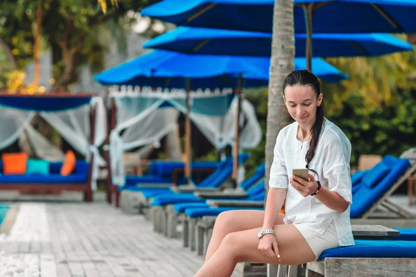 Mujer joven en la arena blanca y hablando por su teléfono — Foto de Stock