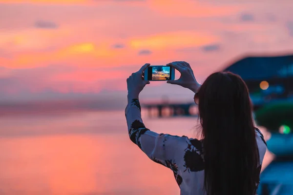 Vrouw foto maken op haar telefoon van prachtige zonsondergang — Stockfoto