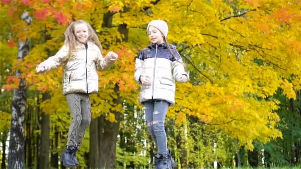 Niñas adorables en el día cálido en el parque de otoño al aire libre — Vídeos de Stock