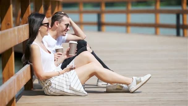 Imagen de una pareja alegre usando smartphones en el parque — Vídeos de Stock