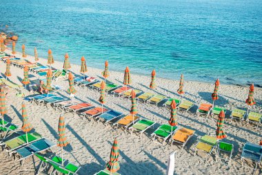 İtalyan sahil üzerinde kapalı şemsiyelerle boş plaj