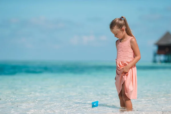 Niedliches Kind spielt mit Papierbooten im Meer — Stockfoto