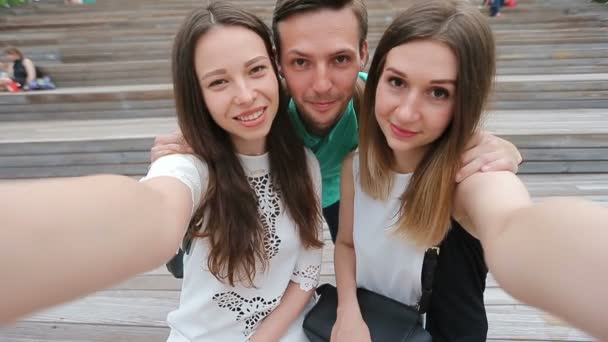 Grupp av lycklig tonåring vänner skrattar och ta en selfie i gatan. Tre vänner tittar tar bilder med TabletPC i park — Stockvideo