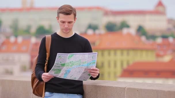 Man tourist with a city map and backpack in Europe. Caucasian boy looking with map of European city in search of attractions. — Stock Footage Man tourist with a city map and backpack in Europe. Caucasian boy looking with map of European city in search of attractions. Stock Footage
