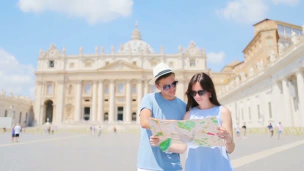 地図の背景を持つ幸せなカップルの観光客イタリア、ローマ、バチカンの聖ペテルス大聖堂教会. — ストック動画