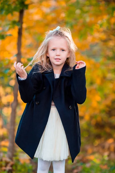 Güzel bir sonbahar gününde dışarıda duran sevimli küçük bir kızın portresi. — Stok fotoğraf