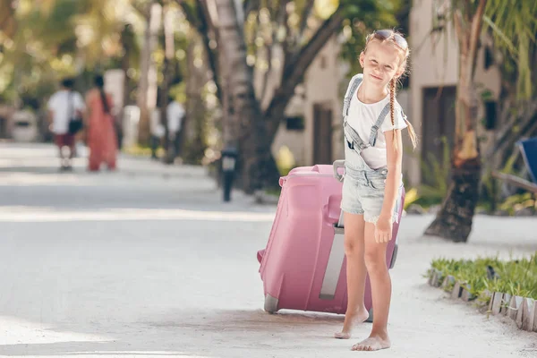 Kleines entzückendes Mädchen mit großem Gepäck im Sommerurlaub — Stockfoto
