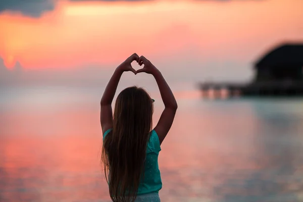 Silueta de corazón hecha a mano por los niños al atardecer —  Fotos de Stock