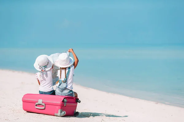 Små flickor med stor resväska och karta på tropical beach — Stockfoto