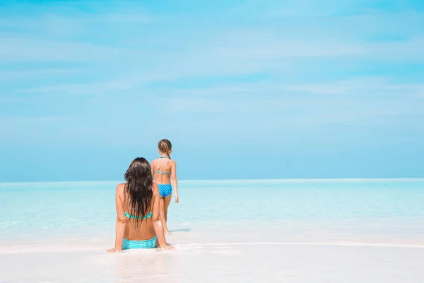 Niña y madre joven durante las vacaciones en la playa —  Fotos de Stock