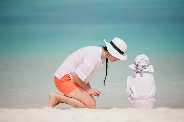 Kleines Mädchen und junge Mutter im Strandurlaub — Stockfoto