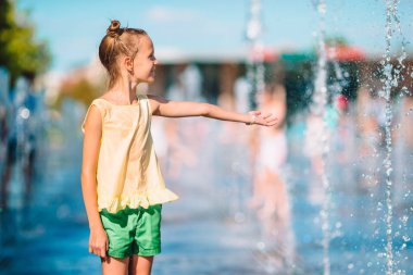 küçük sevimli kız var eğlenceli sokak Çeşmesi sıcak güneşli bir gün