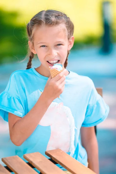 Little girl eating ice-cream outdoors at summer in outdoor cafe — Stock Photo, Image