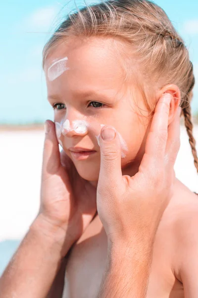 Použití sluneční krém na nos dcera otec. — Stock fotografie
