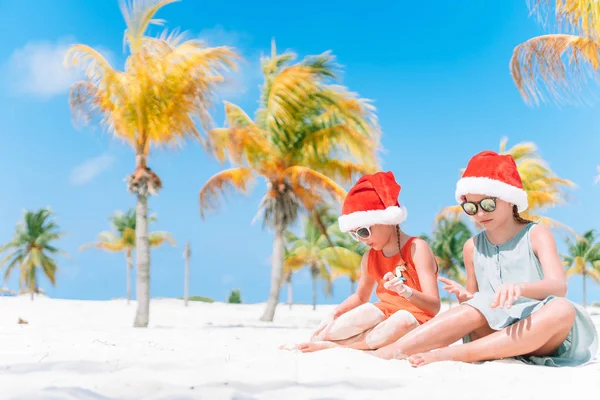 Aranyos kislány a Santa kalap alatt tengerparti nyaralás szórakozni együtt — Stock Fotó