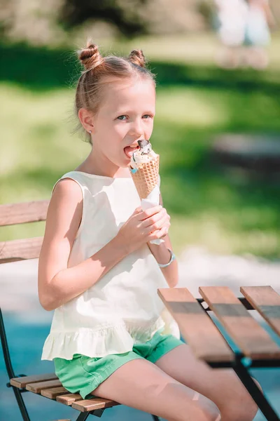 Menina comendo sorvete ao ar livre no verão no café ao ar livre — Fotografia de Stock