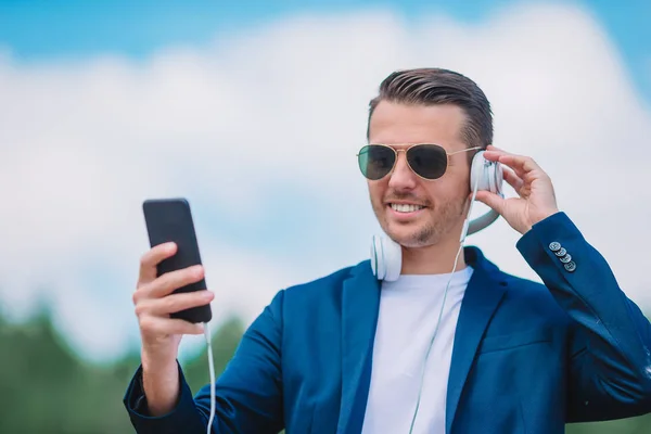 Man is het lezen van SMS-bericht op mobiele telefoon tijdens het wandelen in het park — Stockfoto