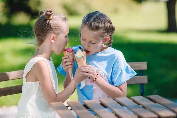 Little girls eating ice-cream outdoors at summer in outdoor cafe — Stock Photo, Image