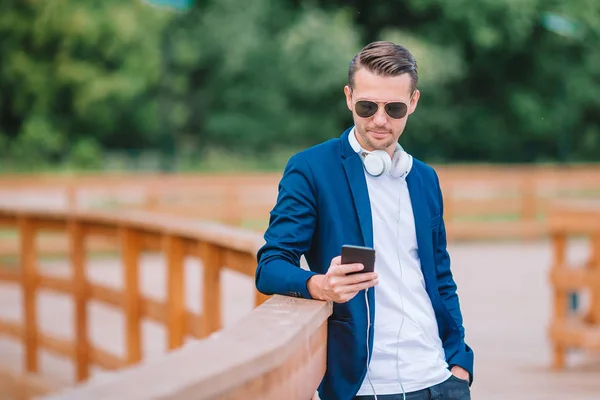 Člověk čte textové zprávy na mobilním telefonu na procházce v parku — Stock fotografie