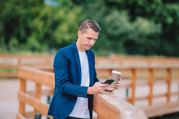 Městské šťastný mladý muž pracovní a pití kávy v Evropské město venku — Stock fotografie