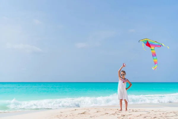 Meisje vliegen een vlieger op strand — Stockfoto