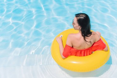 Güzel genç bayan yüzme havuzunda dinleniyor..