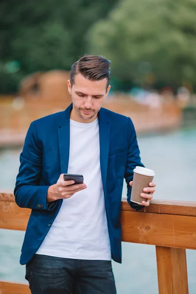 Gelukkig jonge stedelijke man werkt en drinken koffie in Europese stad in openlucht — Stockfoto