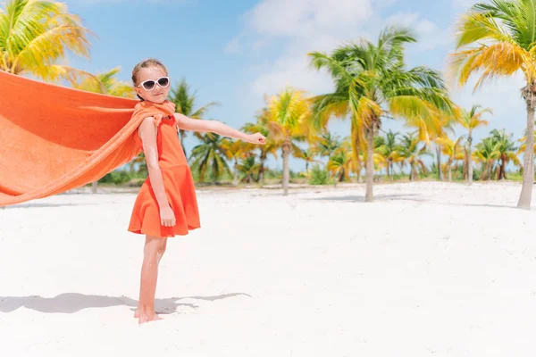 Pequeña chica linda jugando superhéroe en una playa tropical — Foto de Stock