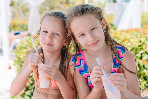 Entzückende kleine Mädchen trinken Milchshake am tropischen Strand — Stockfoto