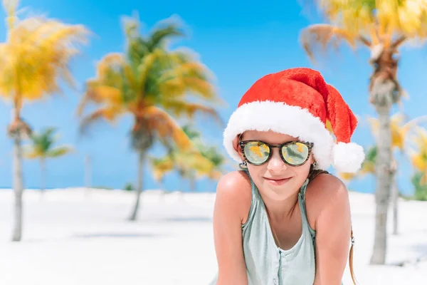 Adorable little girl in Santa hat during Christmas beach vacation — Stock Photo, Image