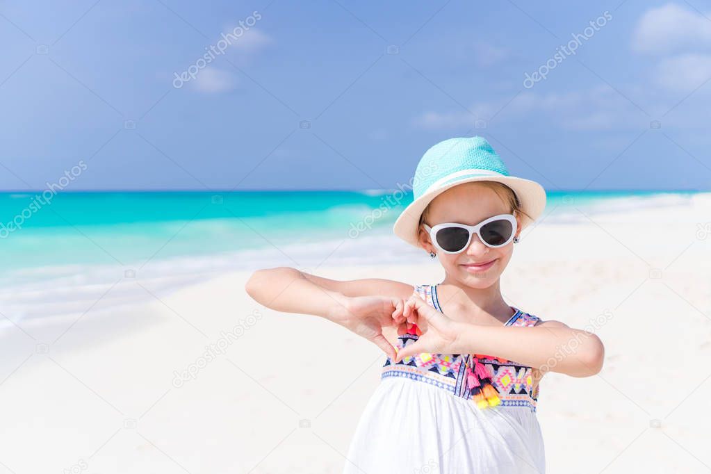 Beautiful little girl at beach having fun. Funny girl enjoy summer vacation.