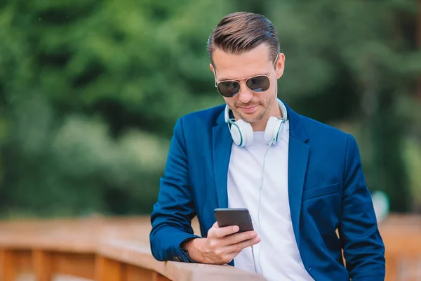 Gelukkig jonge stedelijke man werkt en drinken koffie in Europese stad in openlucht — Stockfoto