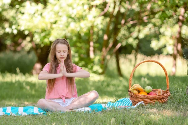 Little girl in yoga position in the park. — Stock Photo, Image