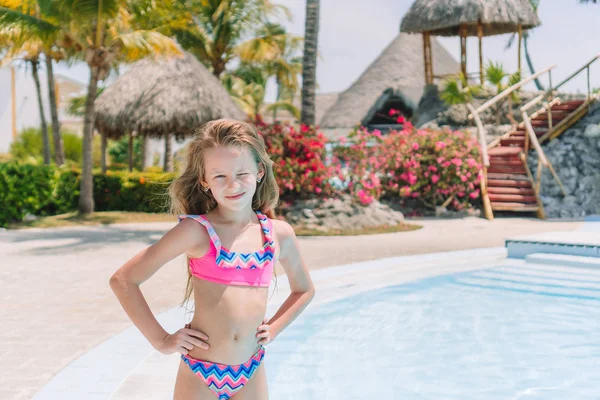 Kleines Mädchen mit Flasche Sonnencreme im Schwimmbad — Stockfoto