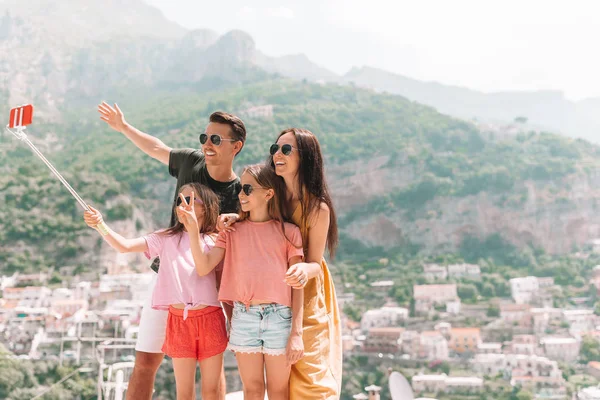 Eltern und Kinder machen Selfie-Foto Hintergrund Positano Stadt in Italien an der Amalfiküste — Stockfoto