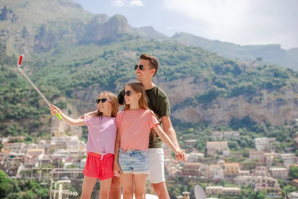 Father and kids taking selfie photo background Positano town in Itali on Amalfi coast — Stock Photo, Image