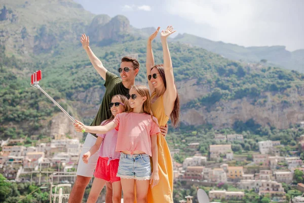 Szülők és gyerekek, hogy szelfi fotó háttér Positano város Olaszországban az Amalfi tengerparton — Stock Fotó