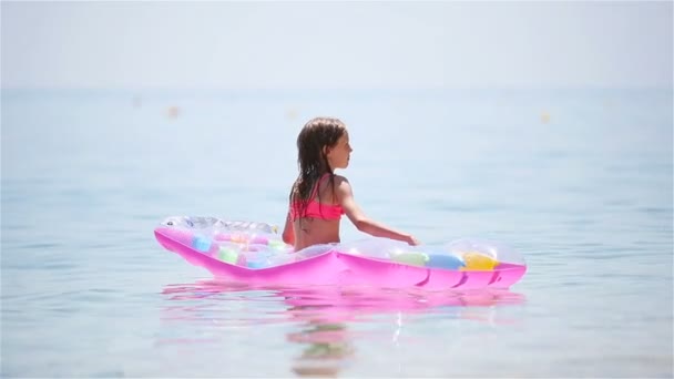 Menina adorável com colchão inflável na piscina exterior — Vídeo de Stock