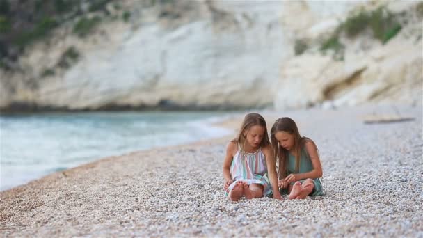 Kleine Mädchen amüsieren sich während der Sommerferien am tropischen Strand beim gemeinsamen Spielen — Stockvideo